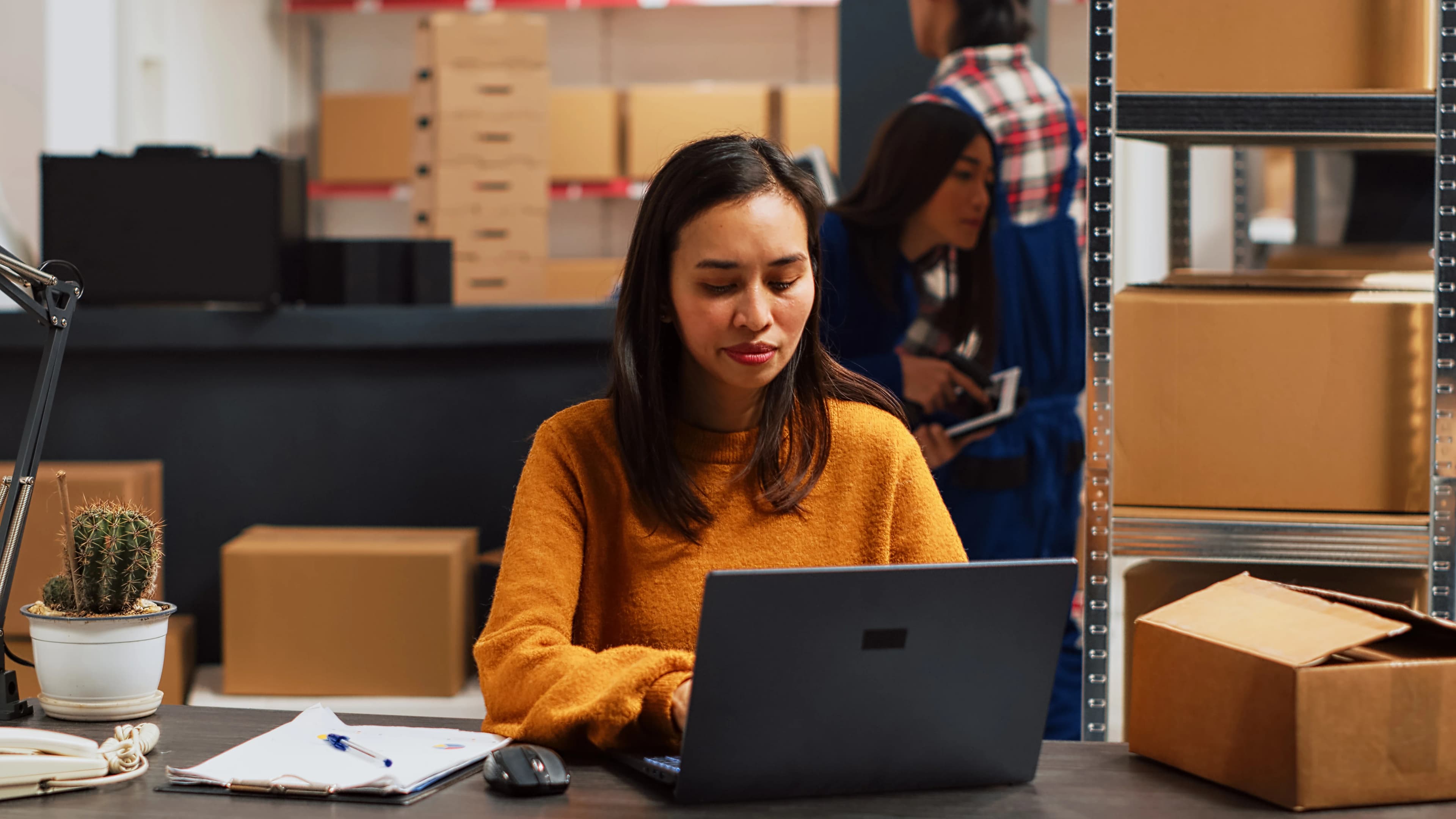 Operations manager reviewing production and inventory data on a laptop