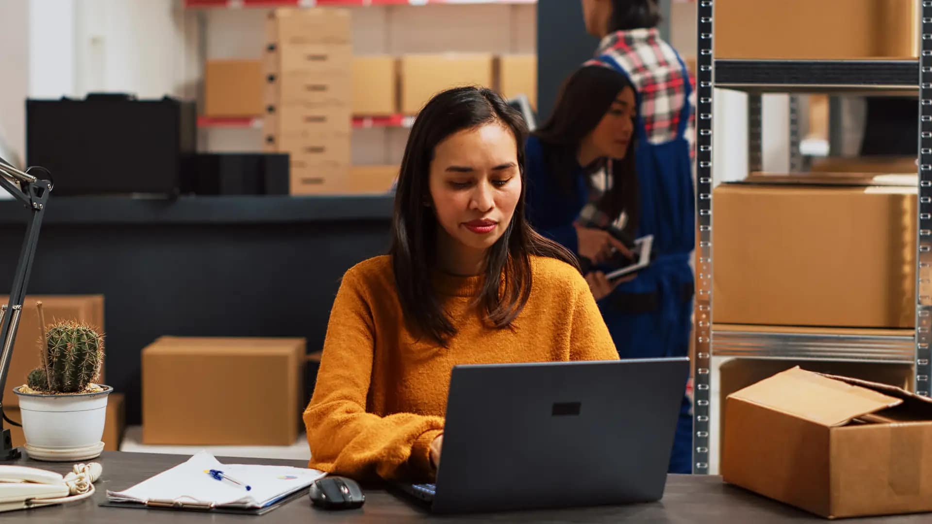 Operations manager reviewing production and inventory data on a laptop
